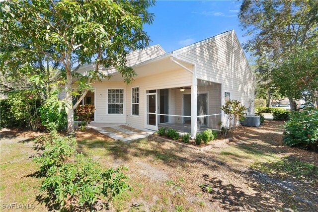 rear view of property featuring cooling unit, a patio area, and a sunroom