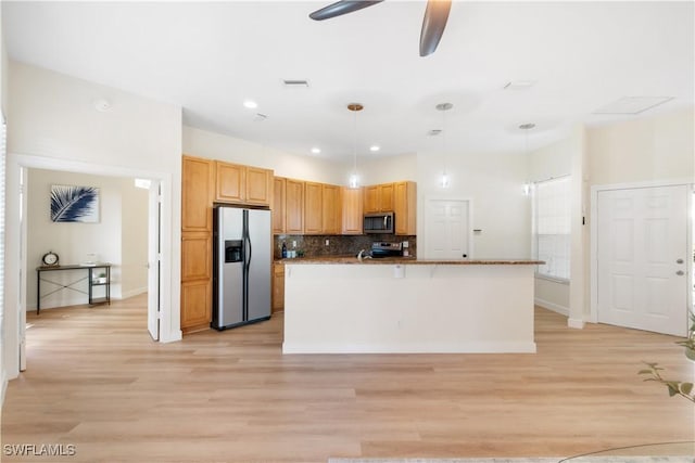 kitchen featuring a kitchen island with sink, light hardwood / wood-style flooring, ceiling fan, appliances with stainless steel finishes, and decorative light fixtures