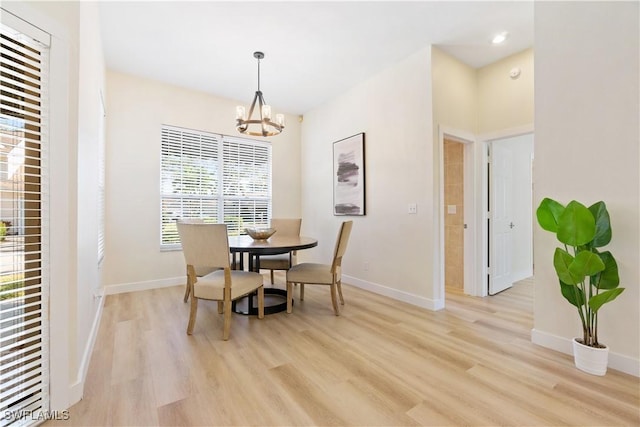 dining space featuring light hardwood / wood-style floors and an inviting chandelier