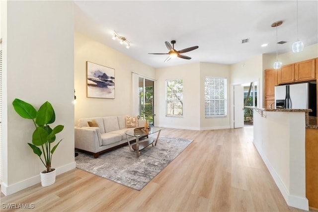 living room featuring light wood-type flooring and ceiling fan