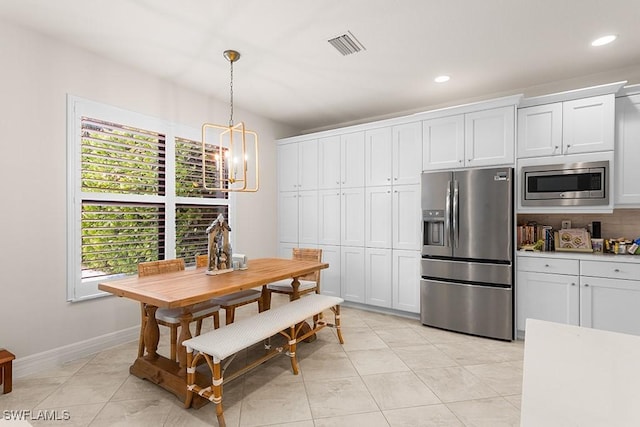 tiled dining room featuring an inviting chandelier