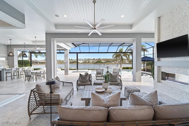 interior space featuring an outdoor living space with a fireplace, glass enclosure, ceiling fan, and a bar