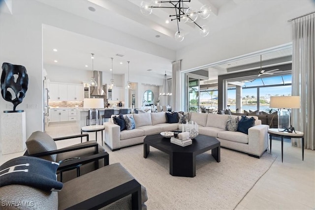 living room with a chandelier, light tile patterned floors, and a water view