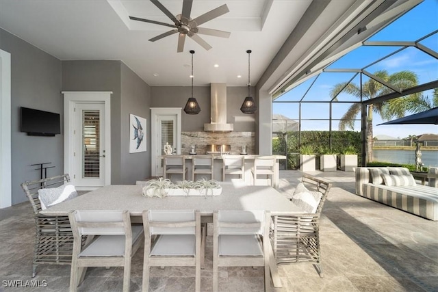 view of patio with glass enclosure, ceiling fan, a water view, and a bar