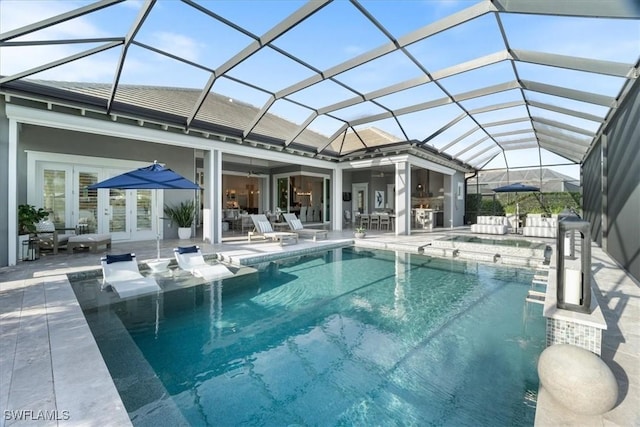 view of pool featuring glass enclosure, french doors, and a patio