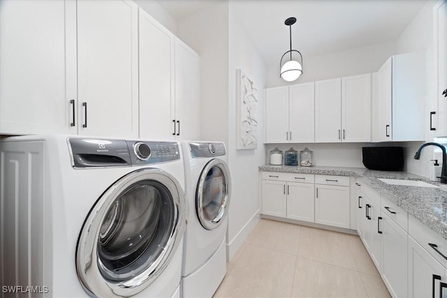 washroom featuring separate washer and dryer, sink, light tile patterned floors, and cabinets