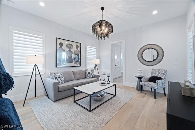 living room with a notable chandelier and light hardwood / wood-style flooring