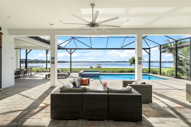 view of patio featuring a lanai, outdoor lounge area, ceiling fan, a swimming pool with hot tub, and a water view