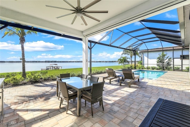 view of patio / terrace with ceiling fan, a water view, and glass enclosure