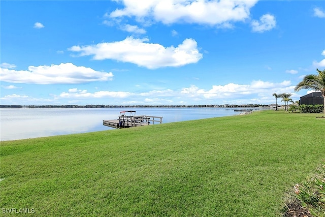 view of dock with a yard and a water view