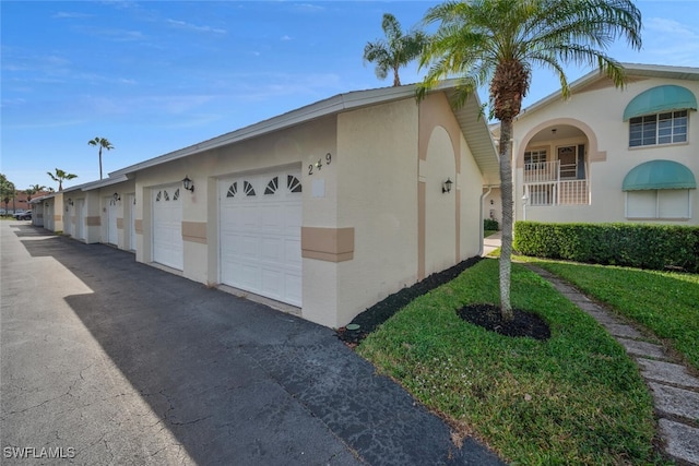 view of side of home with stucco siding and community garages