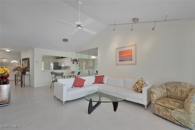 tiled living room with ceiling fan and high vaulted ceiling