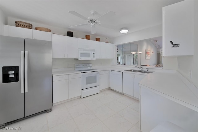 kitchen with white appliances, light countertops, a sink, and white cabinets