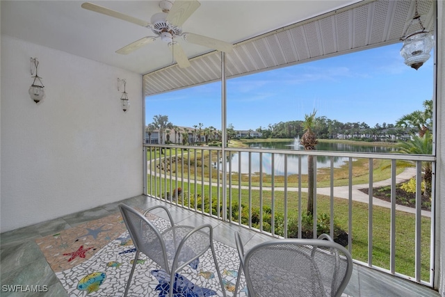 balcony featuring a water view and ceiling fan