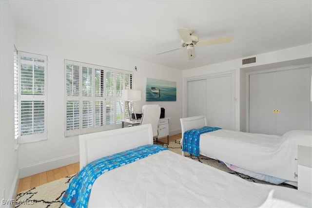 bedroom featuring multiple windows, wood-type flooring, and ceiling fan