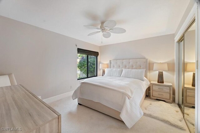 carpeted bedroom with ceiling fan and a closet