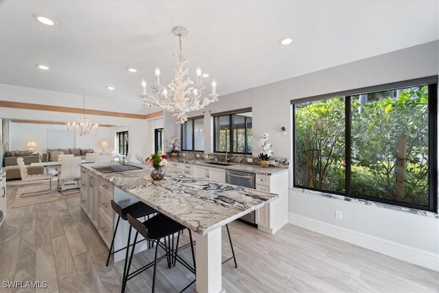 kitchen with stainless steel dishwasher, a spacious island, white cabinetry, hanging light fixtures, and a breakfast bar area