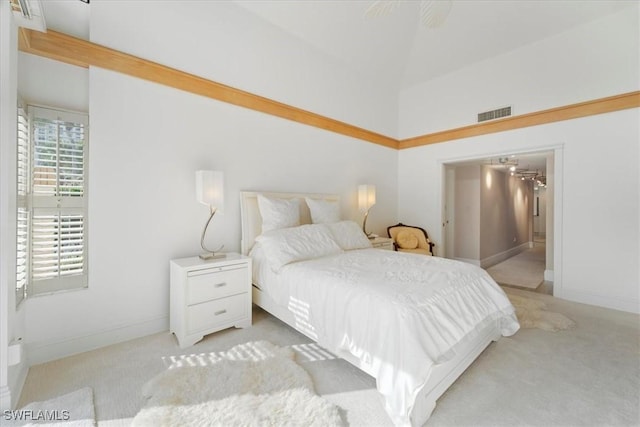 carpeted bedroom with a high ceiling