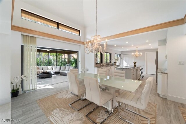 dining room with light hardwood / wood-style floors and an inviting chandelier