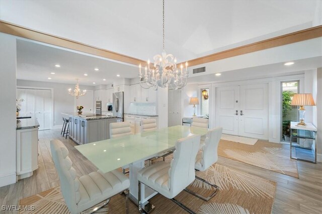 dining area featuring a notable chandelier and light hardwood / wood-style floors