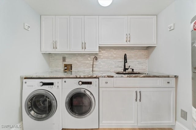 laundry area featuring washer and dryer, cabinets, and sink