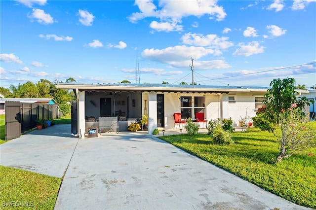 ranch-style house featuring covered porch and a front lawn