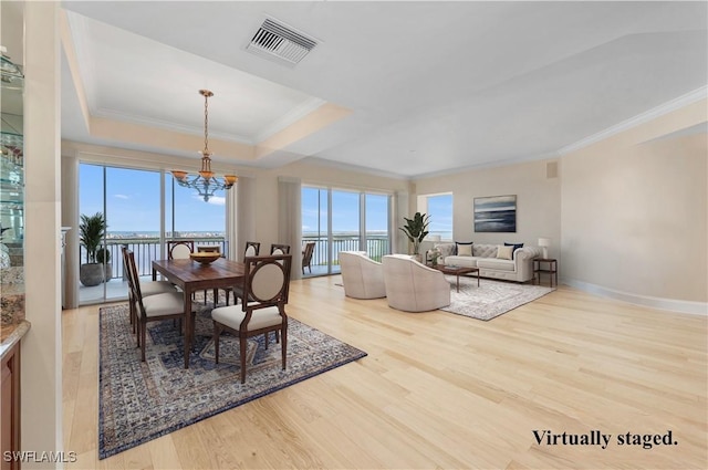 dining space featuring ornamental molding, a healthy amount of sunlight, visible vents, and light wood finished floors