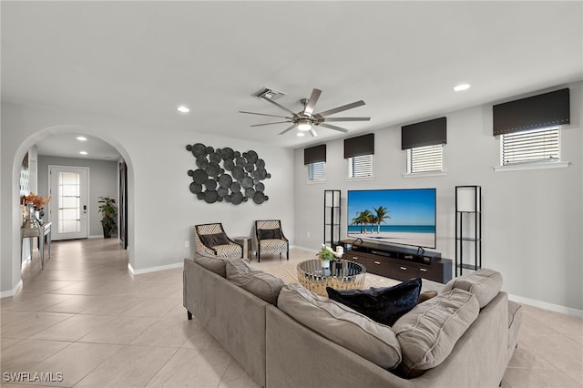 tiled living room with a wealth of natural light and ceiling fan