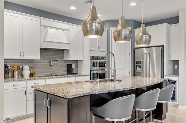 kitchen with visible vents, white cabinets, appliances with stainless steel finishes, custom exhaust hood, and backsplash