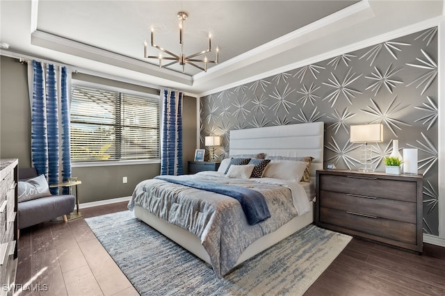 bedroom with a notable chandelier, dark hardwood / wood-style floors, a raised ceiling, and ornamental molding