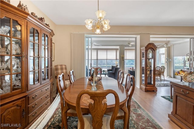 dining space featuring ceiling fan with notable chandelier and light hardwood / wood-style flooring