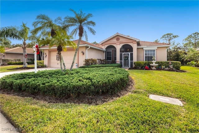 mediterranean / spanish house featuring a front yard and a garage