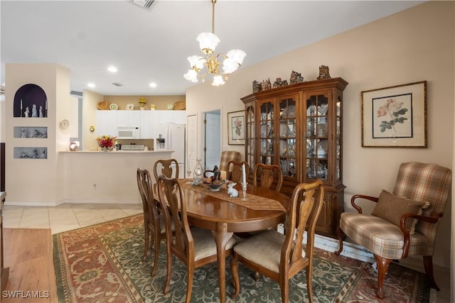 tiled dining room with a chandelier