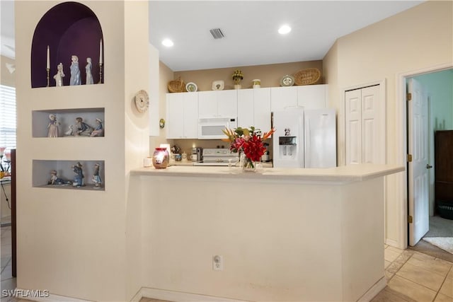 kitchen featuring white cabinets, white appliances, kitchen peninsula, and light tile patterned floors