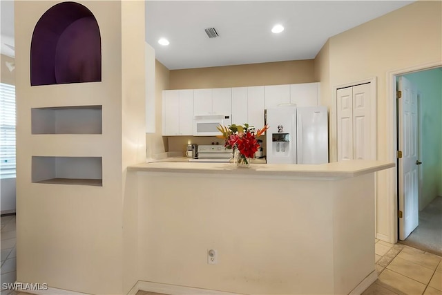 2320 Palo Duro Blvd, North Fort Myers, FL 33917 - kitchen with white appliances, a peninsula, white cabinetry, light countertops, and light tile patterned floors
