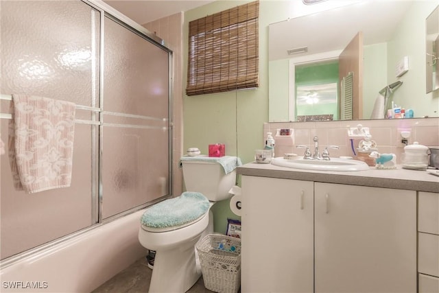 full bathroom featuring toilet, combined bath / shower with glass door, backsplash, and vanity