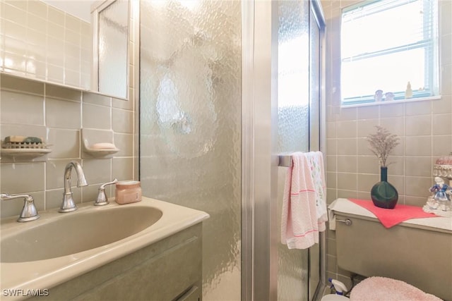 bathroom with vanity, backsplash, an enclosed shower, and tile walls