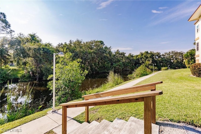 surrounding community featuring a lawn and a water view