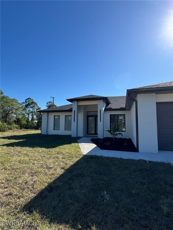 view of front of property with a garage and a front lawn