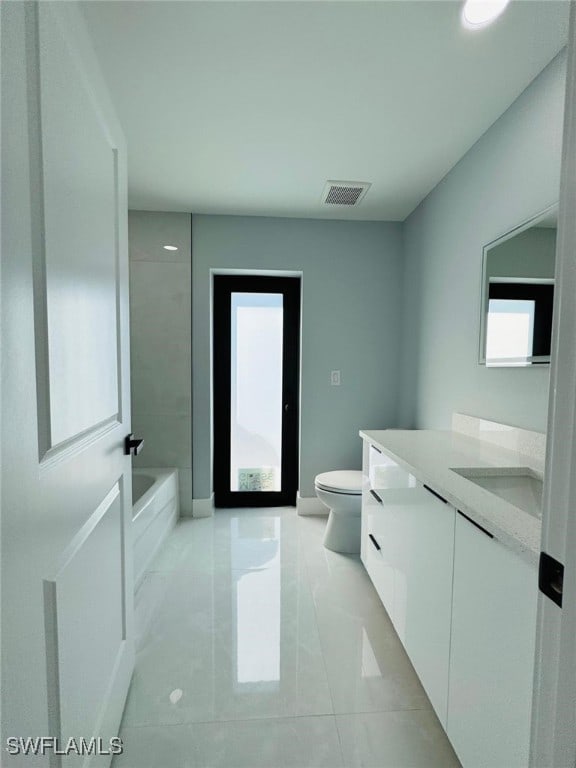 bathroom with tile patterned flooring, vanity, and toilet