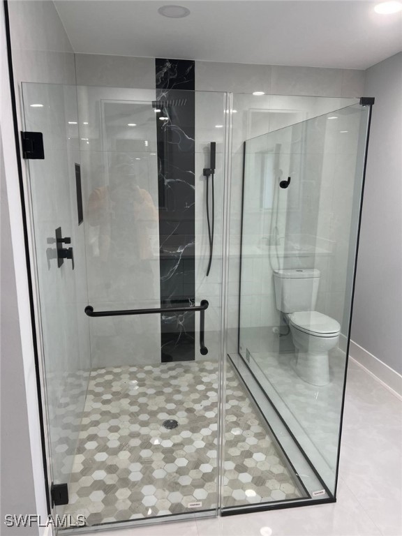 bathroom with toilet and a shower with shower door