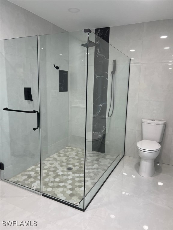 bathroom with an enclosed shower and toilet