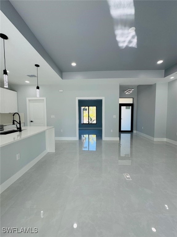 unfurnished living room featuring sink