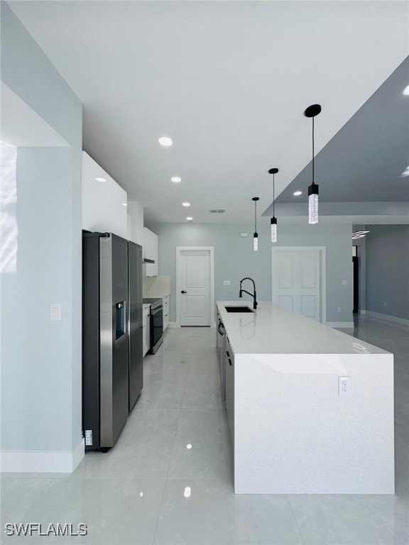 kitchen with white cabinetry, sink, stainless steel refrigerator with ice dispenser, an island with sink, and pendant lighting