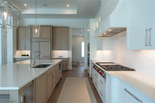 kitchen featuring white cabinets, a spacious island, hanging light fixtures, light stone countertops, and stainless steel gas cooktop