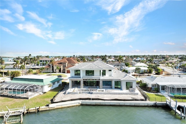 back of property with a water view and a patio