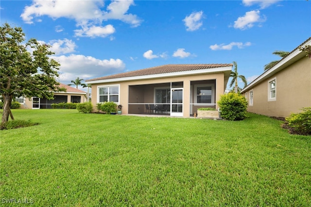 rear view of house with a yard and a sunroom