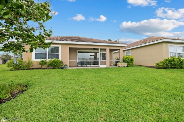 rear view of property featuring a sunroom and a yard