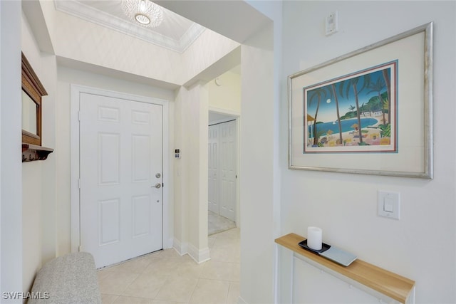 entrance foyer featuring light tile patterned floors and crown molding