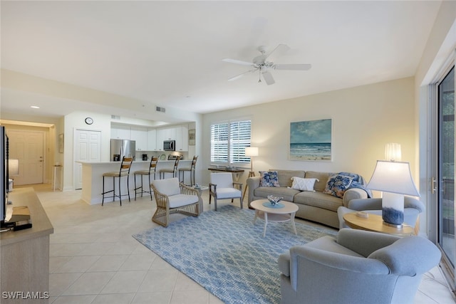 living area with light tile patterned floors, ceiling fan, and visible vents